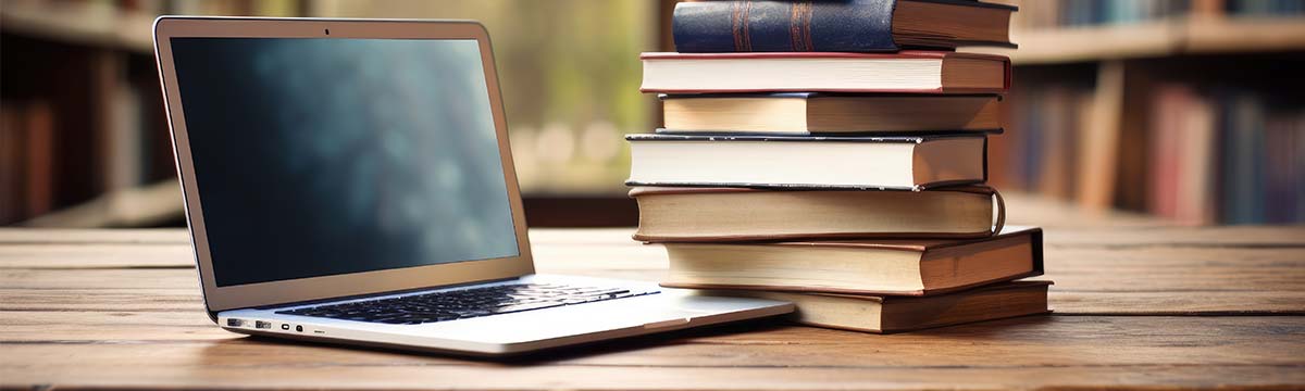 laptop next to old books.