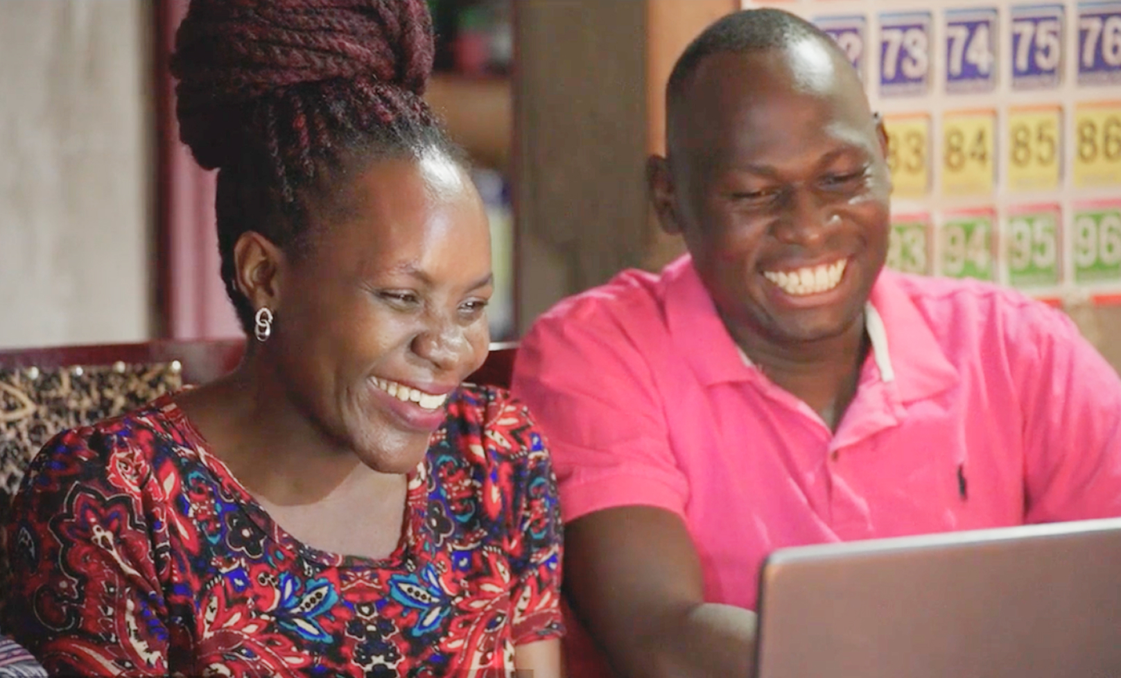 Faith and Vianney Ssenyonga from Uganda sitting at a computer together reviewing courses offered through BYU-Pathway.