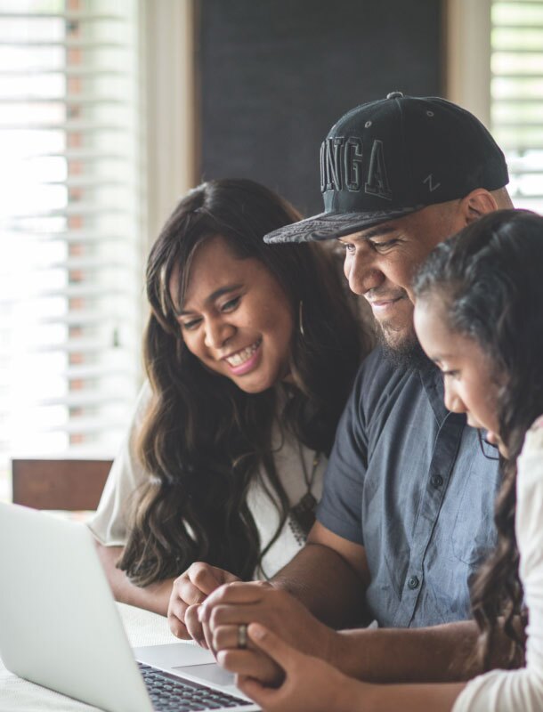 Family smiling sitting at the table with laptop