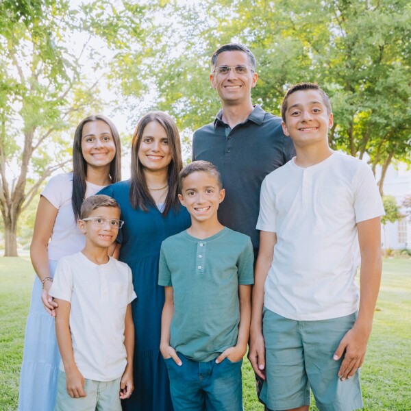 Karine Maia and her husband stand outside with their four children, who they teach in their home the value of education.