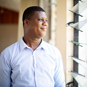 A BYU-Pathway Worldwide student looks out a classroom window in Africa.