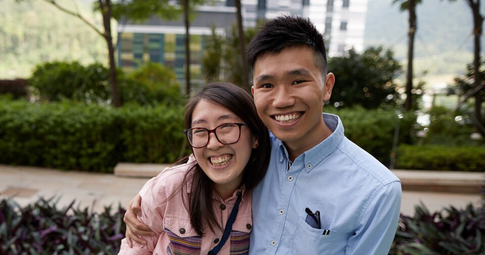 Two students standing side by side, smiling