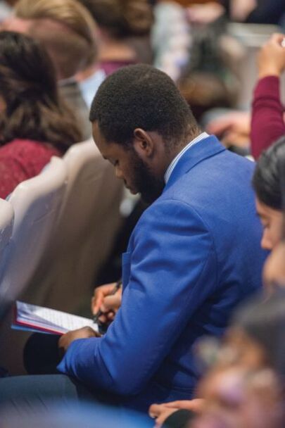 BYU-Pathway student taking notes during the broadcast by Elder Jeffrey R. Holland