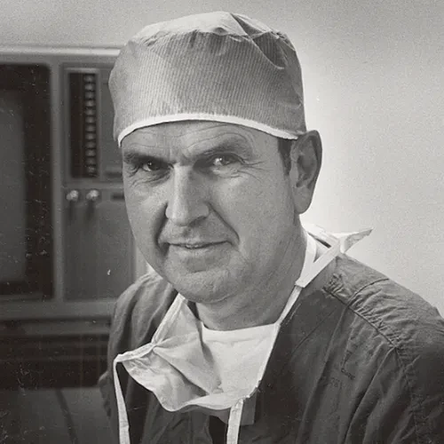 President Russell M. Nelson working as a surgeon, wearing scrubs and a surgeon cap.
