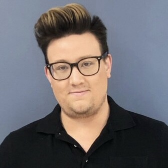 After cutting hair for over ten years, going back to school helped Chris discover renewed strength. He stands, smiling.