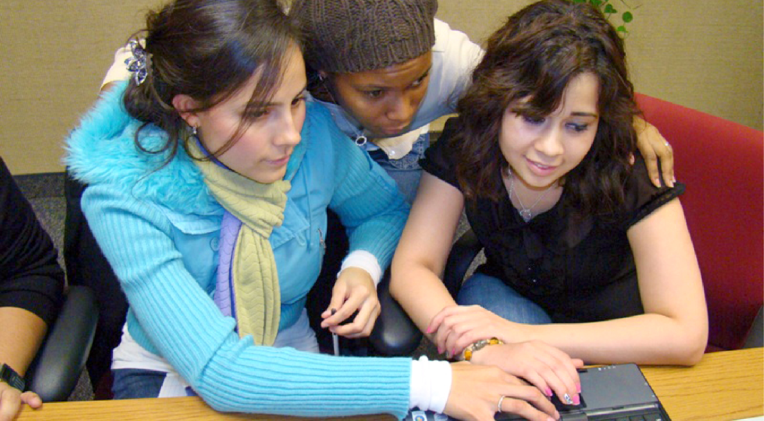 Three students looking at laptop