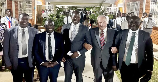Elder Rasband, an apostle of the Church of Jesus Christ of Latter-day Saints, links arms while walking with saints in Uganda