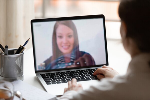 Indian lady lead videocall, pc screen view over woman shoulder