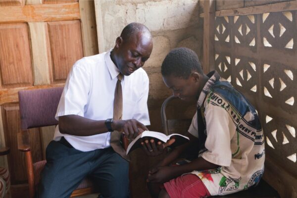 african father and son studying scriptures