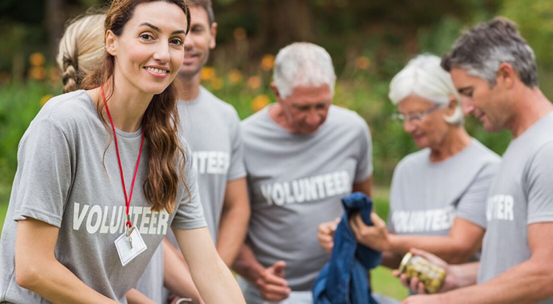 Happy volunteer looking at donation box