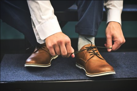 man tying his dress shoes