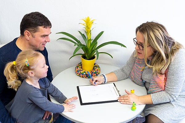 Father and toddler daughter in therapist office during counselling assessment meeting.