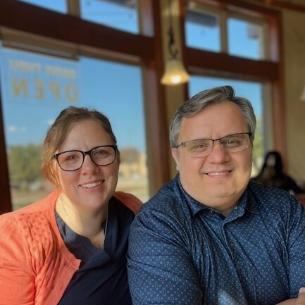 BYU-Pathway graduate Timothy Zufelt and his wife smile together, celebrating his achievement at a restaurant.